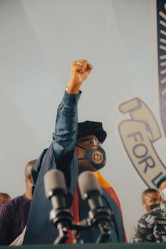 Man Holding a Fist in the Air at a Press Conference